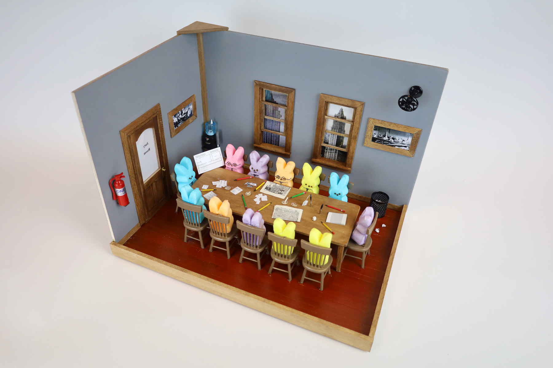 Nick Comande, 12 Angry Peeps (a) Many bunny peeps surround the table of an office in a city. They have tiny newspapers on the table as well as a trash can, fire extinguisher, and an office water dispenser in the corners.